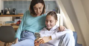 Une mère et sa fille regardent un téléphone