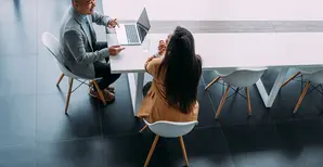 foto dall&#039;alto di due persone che parlano tra loro davanti ad un pc