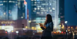 Young women holding Tablet looking at Skyline