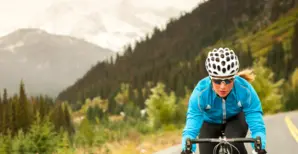 Woman biking on mountain road