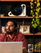 Man on computer with headphones on