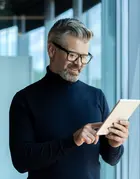 Geschäftsmann liest News auf dem Tablet