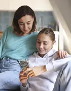 Une mère et sa fille regardent un téléphone