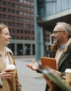 3 colleagues standing and talking together at a modern city center