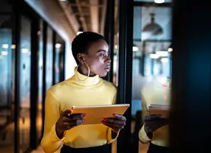 Woman in yellow top in office with tablet