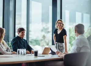 Group of people sitting around a table in an office