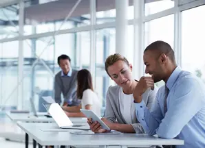 people looking at a tablet in office