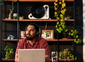 Man on computer with headphones on