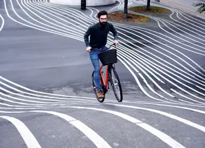Man cycling on paved surface with lines