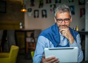 Older man looking at tablet thoughtfully