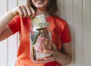a woman putting cash in a jar