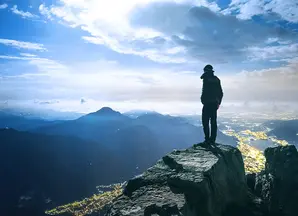 panorama di montagne e persona in primo piano che guarda l&#039;orizzonte