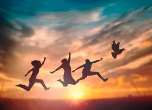 Silhouette de trois personnes qui sautent et d'un oiseau