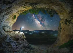 Best ideas fondi azionari header - immagine con cielo stellato visto da una montagna con uomo con una torcia in mano