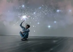 immagine di ragazzo seduto sul pavimento con visore che proietta stelle