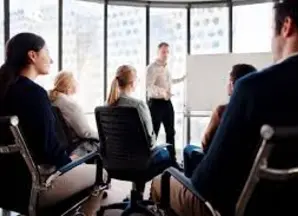 Un homme fait une présentation sur un tableau blanc
