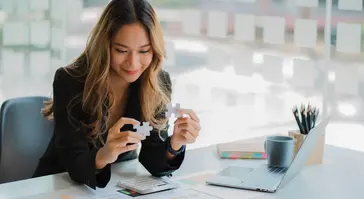 businesswoman finding solution to a jigsaw 