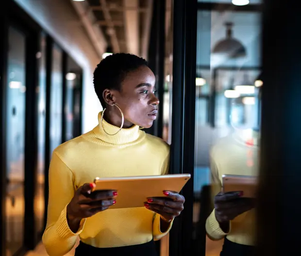 Woman in yellow top in office with tablet