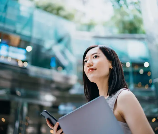 Woman outside office with folder and phone