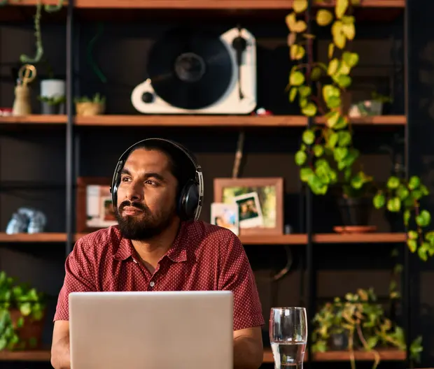 Man on computer with headphones on