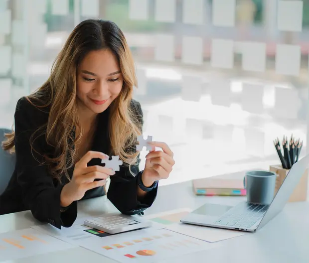 businesswoman finding solution to a jigsaw 