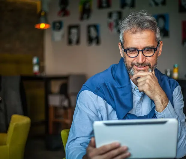 Older man looking at tablet thoughtfully