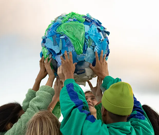 gruppe mit weltkugel aus plastikabfall