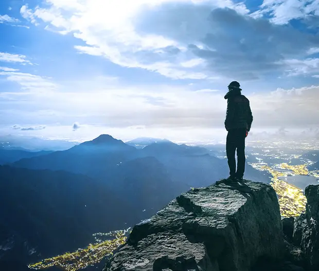 panorama di montagne e persona in primo piano che guarda l&#039;orizzonte