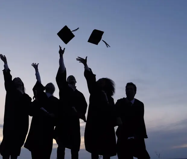 graduating student throwing caps in the air