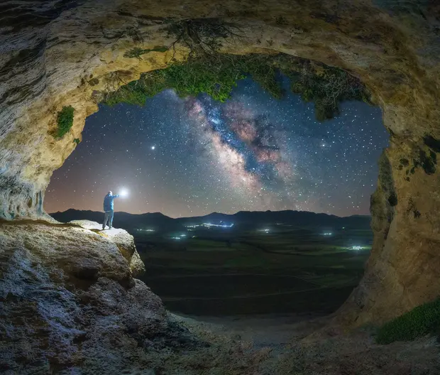 Best ideas fondi azionari header - immagine con cielo stellato visto da una montagna con uomo con una torcia in mano