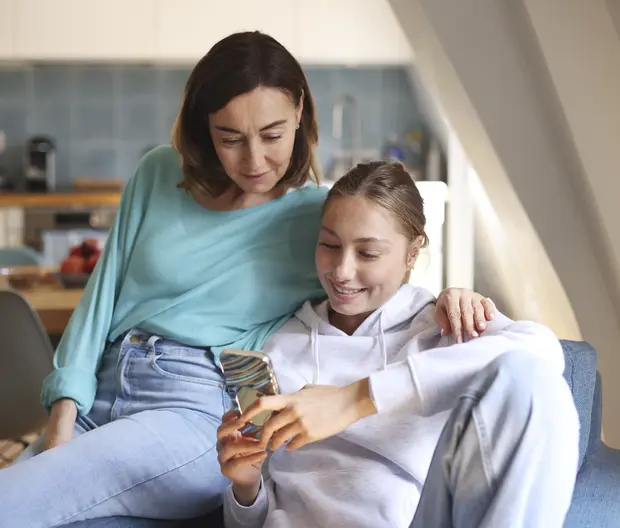 Une mère et sa fille regardent un téléphone