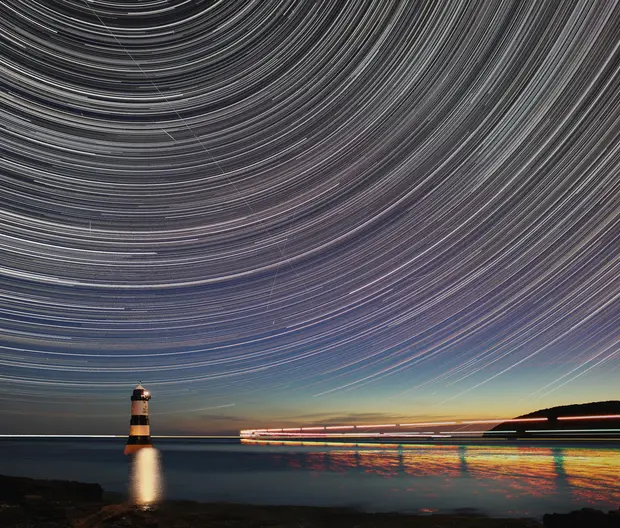 faro sul mare nella notte
