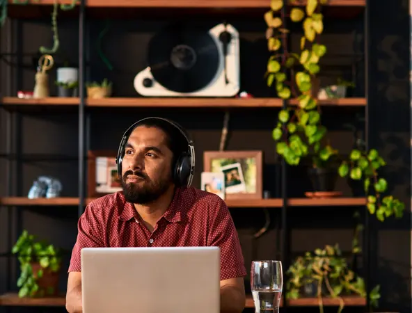 Man on computer with headphones on