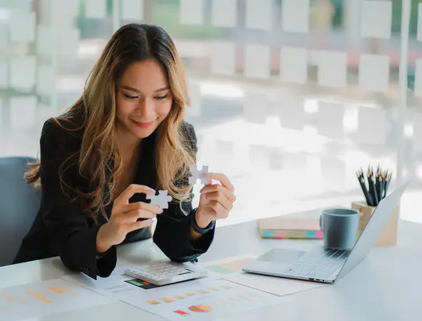 businesswoman finding solution to a jigsaw 