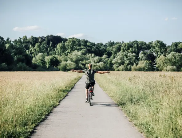Riding bike along path through field