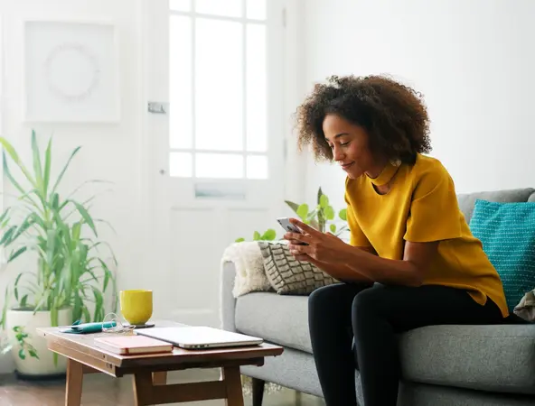 Woman sitting on couch with phone