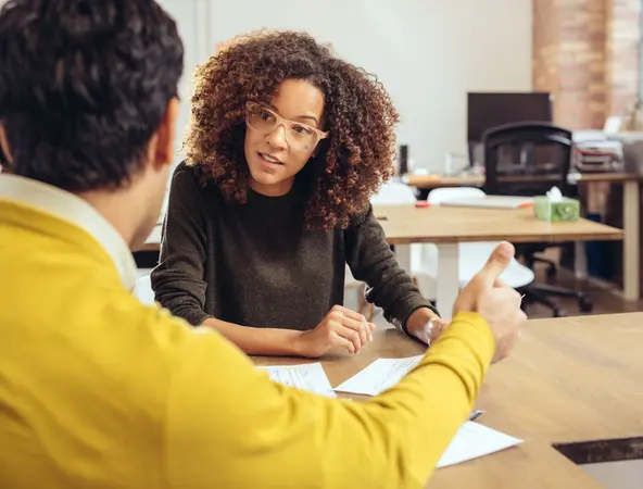 Woman sitting at a table talking to another person