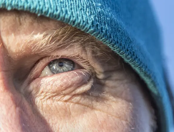 Nahaufnahme Auge einer Person mit blauer Mütze