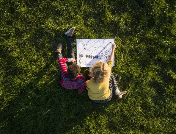 boy_and_girl_on_grass_experimenting_and_drawing_sustainable_energy_solutions