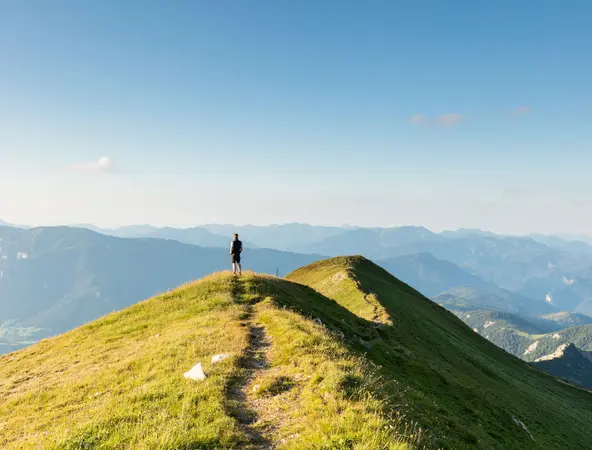 Person standing on a grassy hill
