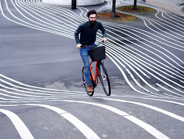 ragazzo in bici su strada con strisce bianche