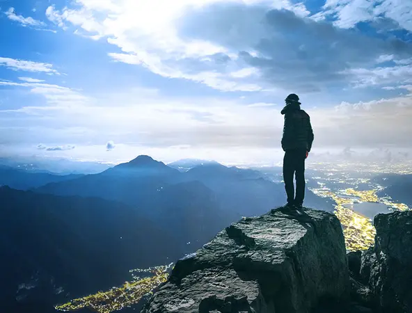 panorama di montagne e persona in primo piano che guarda l&#039;orizzonte