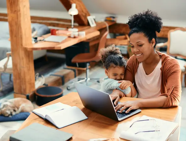 mother working while child is hugging her