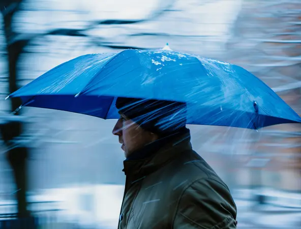 man braving the rain with a strong umbrella