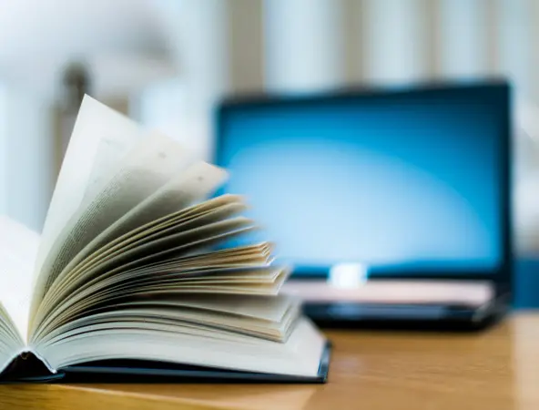 Un livre devant un ordinateur