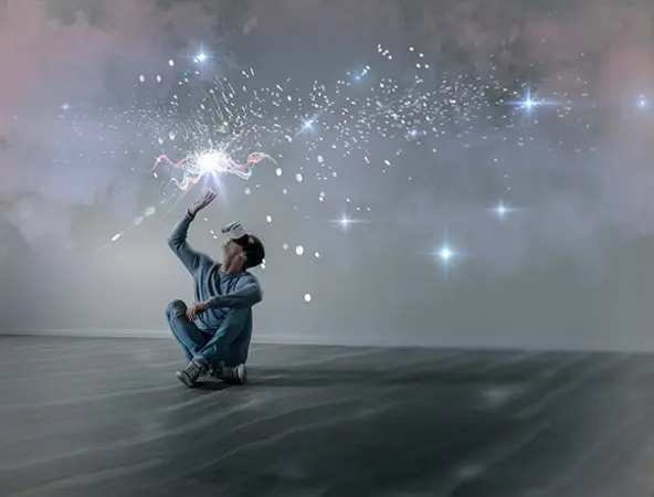 immagine di ragazzo seduto sul pavimento con visore che proietta stelle