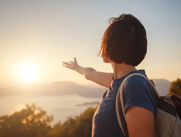 immagine di donna che ammira il tramonto all&#039;orizzonte