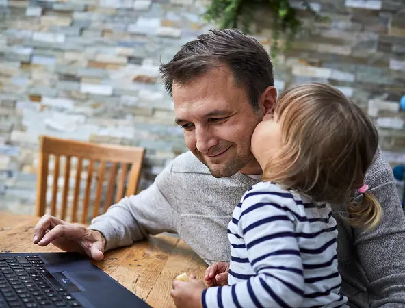 Vater mit Kind am Laptop - warum investieren wichtig ist