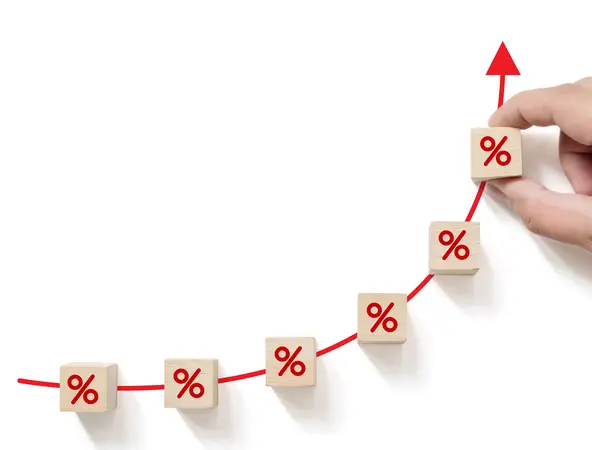 Interest rate financial and mortgage rates concept. Hand putting wood cube block increasing with icon percentage symbol upward direction