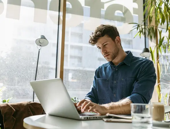 young man working on his laptop in a cafe